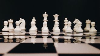 Chess pieces lined up on a board.